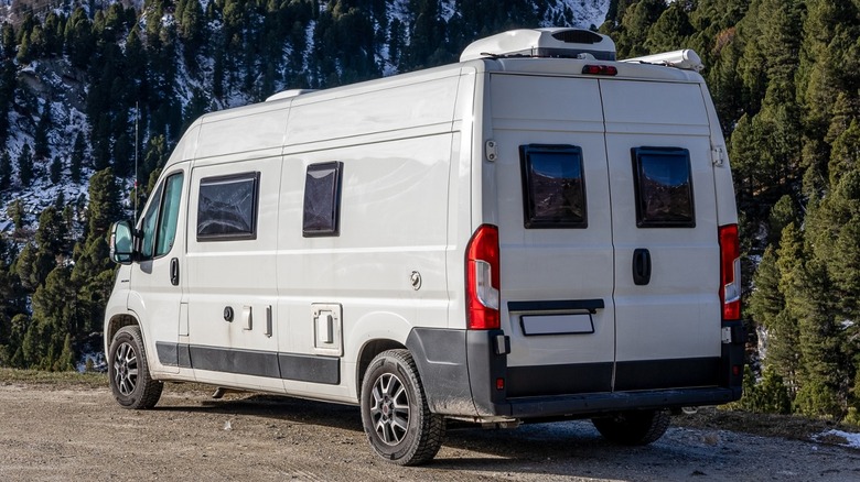 White campervan parked dirt mountains