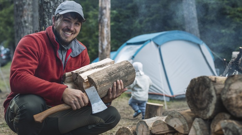 Man holding wood and axe in hands