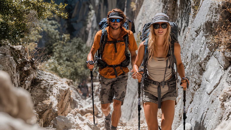 Two people on a hiking trail using carbon fibre trekking poles