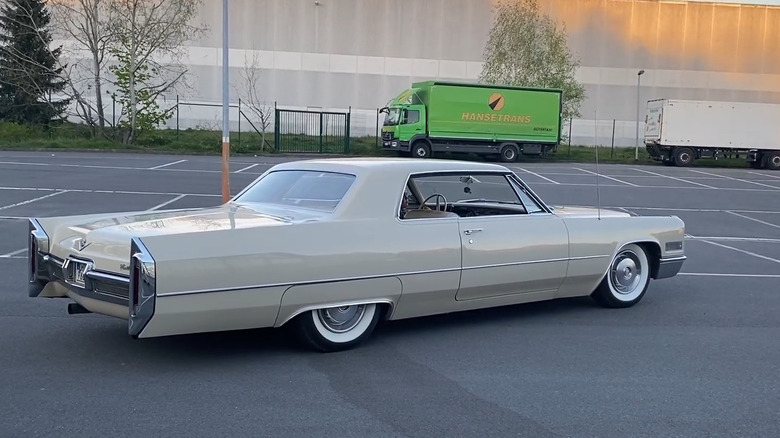 The right rear-three-quarter view of a beige 1960s Cadillac Coupe Calais, showing the impressive length of the car.