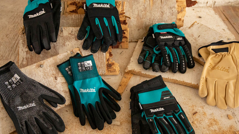Several Makita work gloves laid out on scraps of wood
