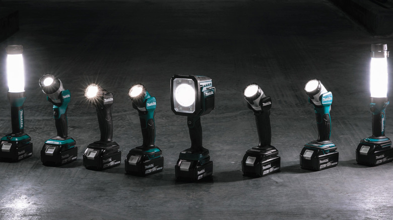 A lineup of Makita flashlights on a gray floor.