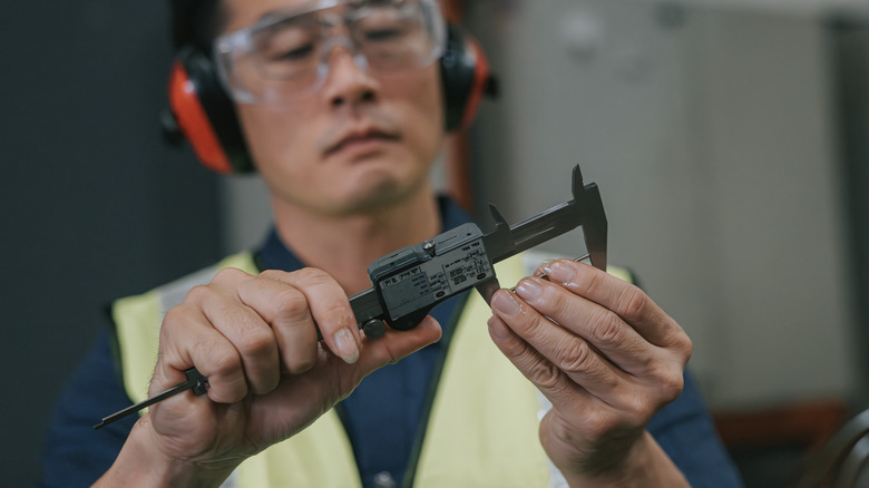 measuring a small part with calipers