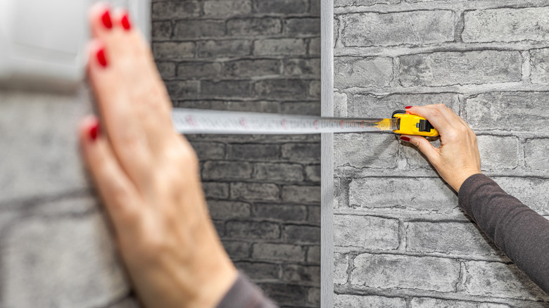 measuring a wall with tape measure