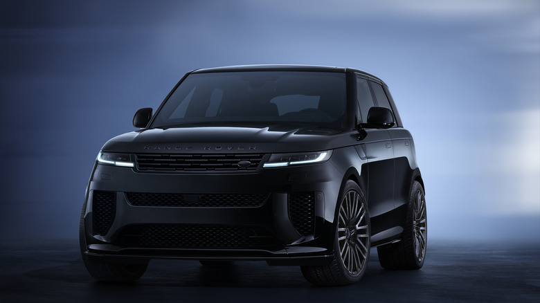 A black Land Rover Range Rover Sport in the SV trim standing against a blue abstract background, front three-quarters view shown.