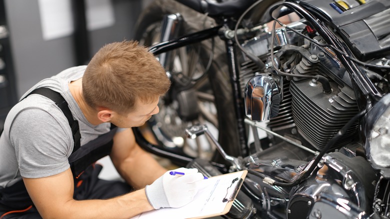 person diagnosing motorcycle