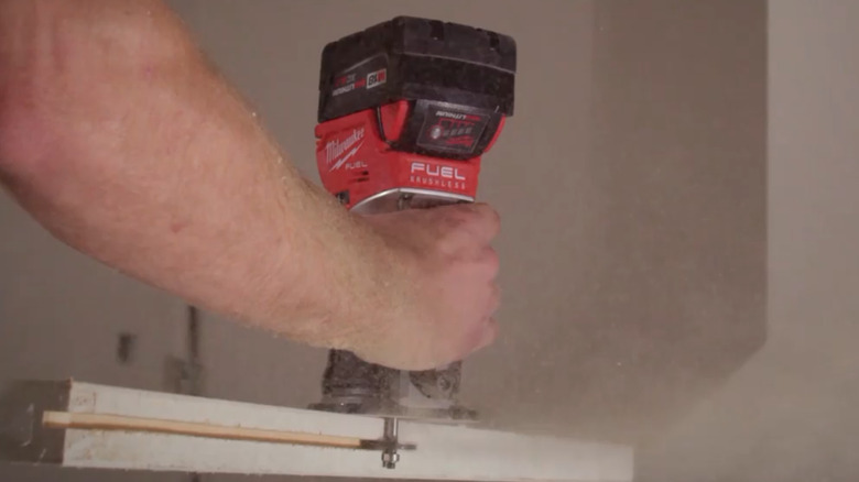 Milwaukee Compact Router being used on the side of a wood piece
