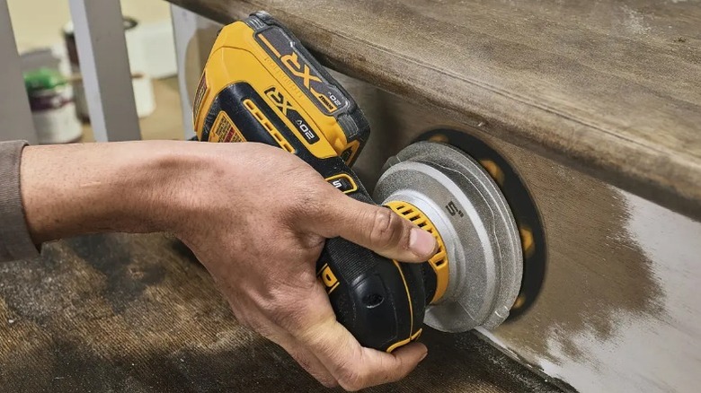 Person sanding steps with DeWalt 20V Max XR 5-inch Random Orbital Sander