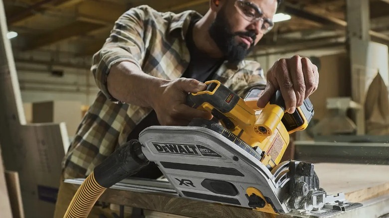 Person cutting board with DeWalt 20V Max XR 6 ½-inch Plunge Track Saw