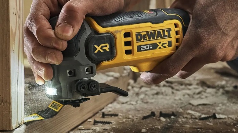 Person trimming frame with DeWalt 20V Max XR Oscillating Multitool