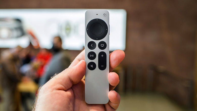 A person holding a Siri Remote