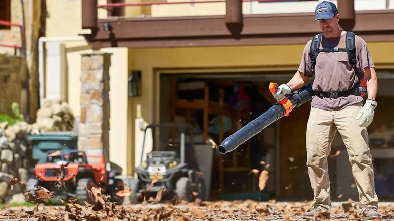 Person blowing leaves using an Atlas 80V dual-port backpack blower