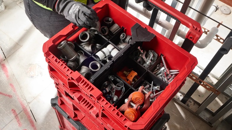 A person reaching into a Milwaukee crate.
