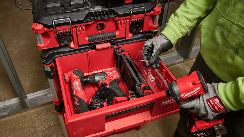 Person removing a drill bit from a drawer in a red Packout tool box