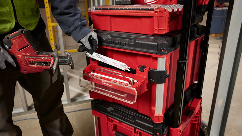 Person placing a Sawzall blade into a storage tray attached to red Packout stack