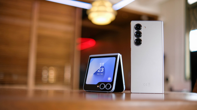 A half-folded clamshell smartphone next to an upright, regular smartphone