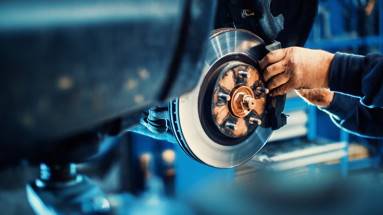 A mechanic installing a rotor on a passenger vehicle