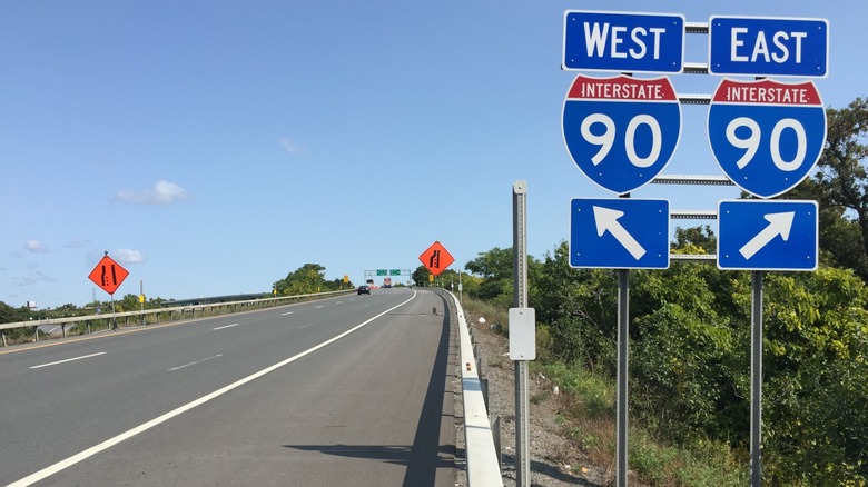 A highway junction showing Interstate 90 signs for both West and East