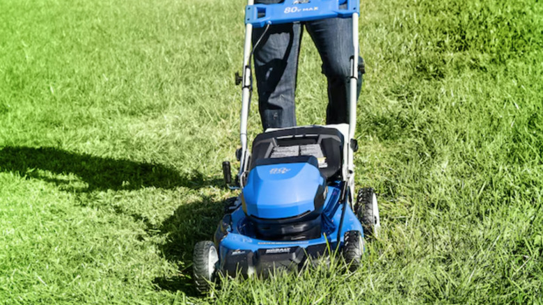 Man using Kobalt electric mower to cut grass