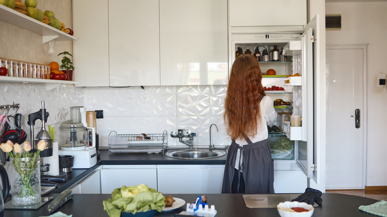 Woman getting food out of a refrigerator