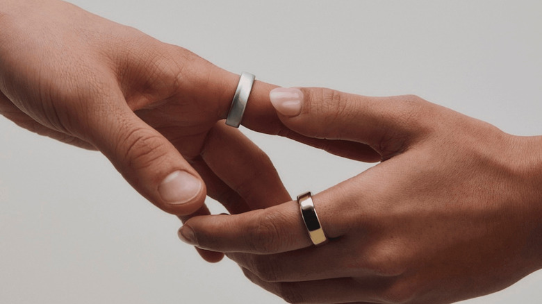 Two hands wearing the Oura Ring 5