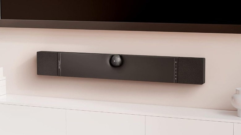 Devialet Dione soundbar wall-mounted on a pink wall under a TV
