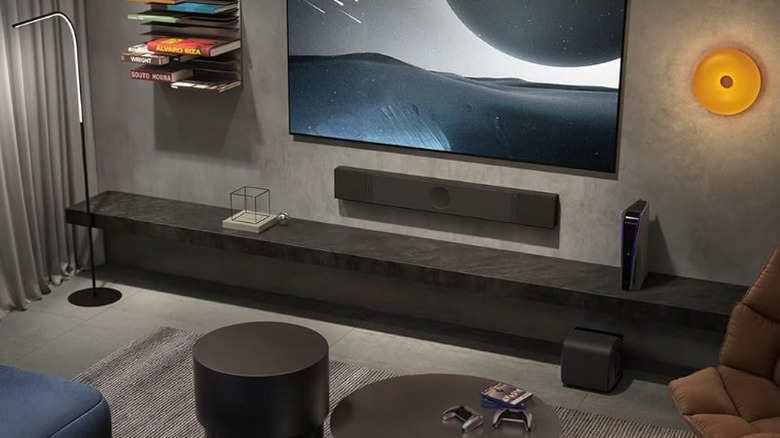 KEF XIO soundbar wall-mounted beneath a TV in a room.