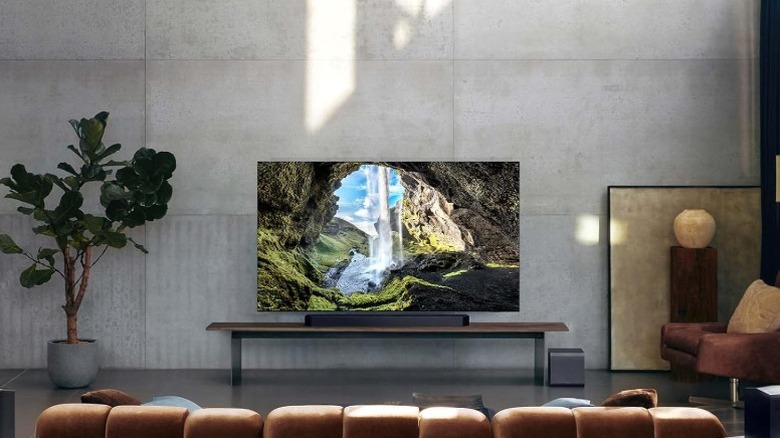 Samsung HW-Q990F soundbar and subwoofer in a minimalist living room with a concrete wall