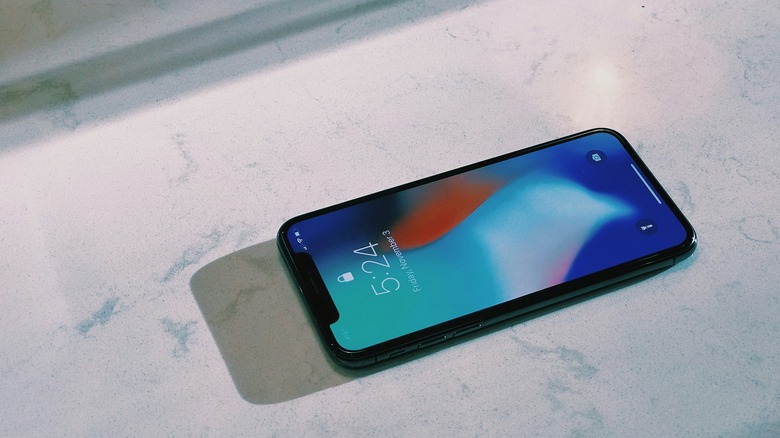 iPhone on a a flat surface with generic wallpaper on the lock screen