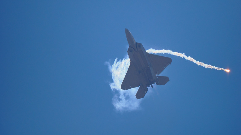 An F-22 Raptor doing maneuvers following the launch of a flare