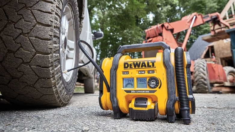 Person inflating tire with DeWalt inflator