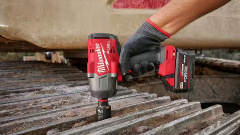 Milwaukee drill driving bolt into metal