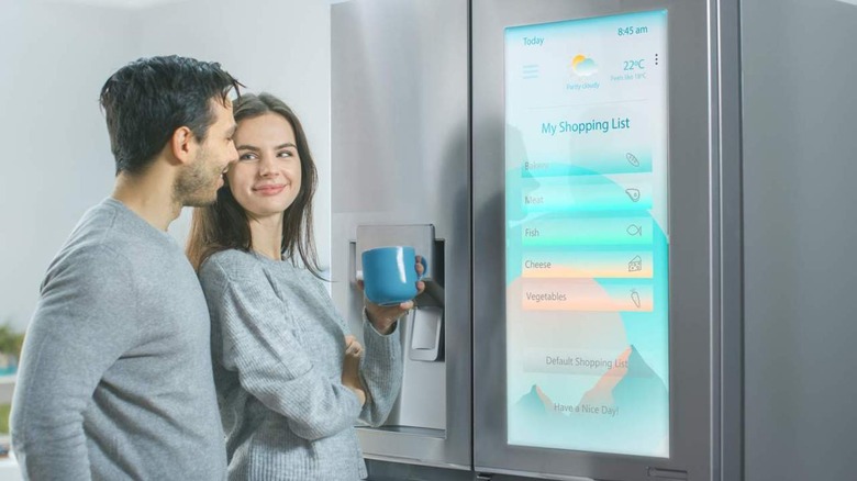 Happy couple with smart fridge 