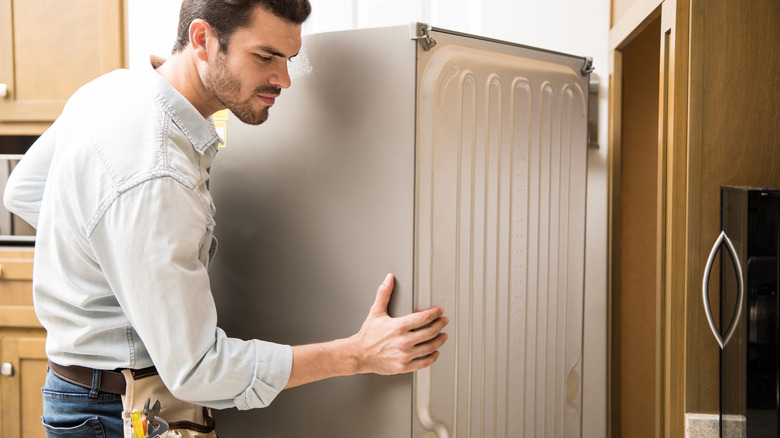 technician inspecting home fridge