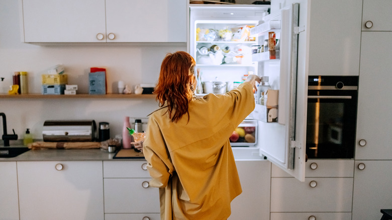 woman looking in home fridge