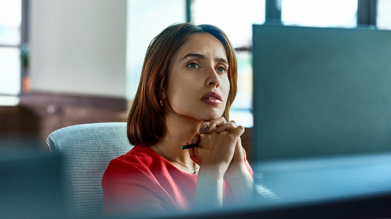 woman thinking deeply in front of computer