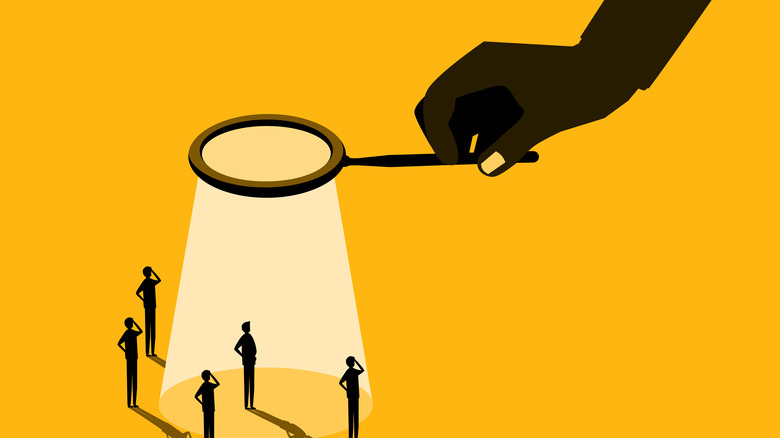 Clip art of hand holding magnifying glass over small people
