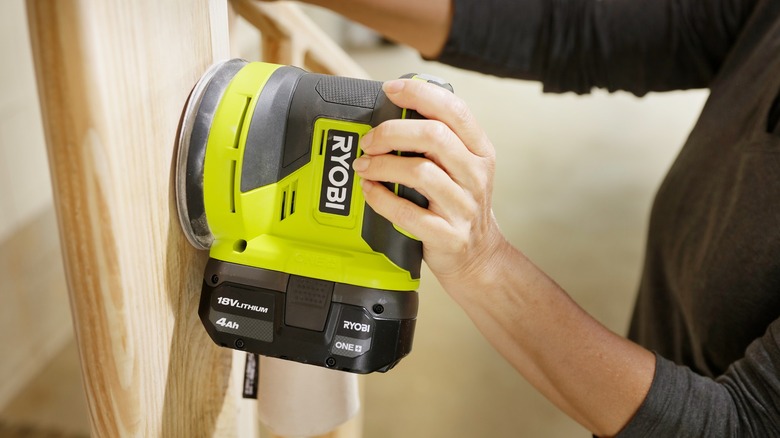 person using ryobi sander