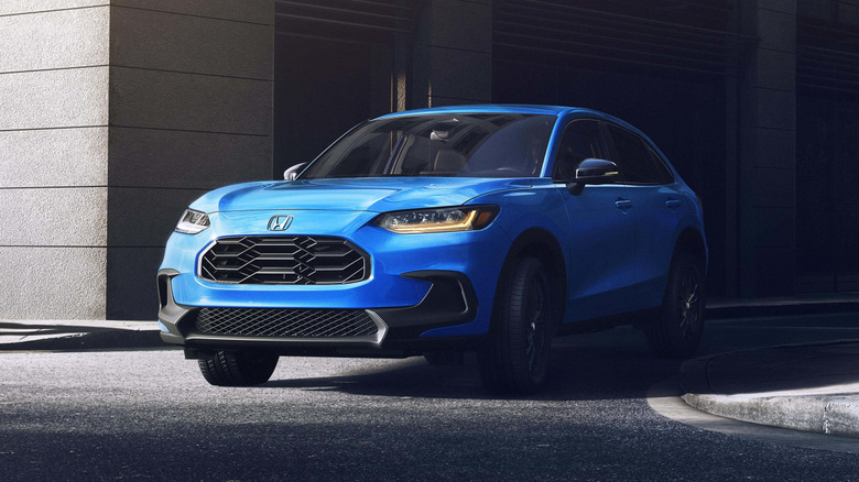 A blue 2026 Honda HR-V exiting a narrow city backstreet