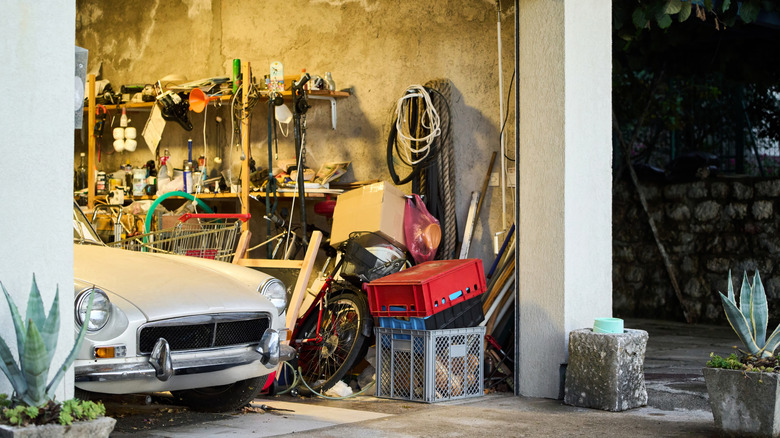 A car parked in a cluttered garage