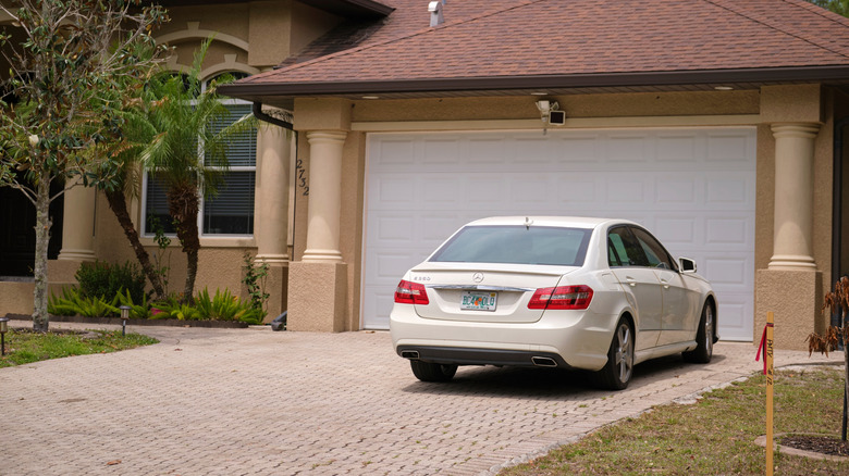 A Mercedes-Benz parked in the driveway in front of a garage