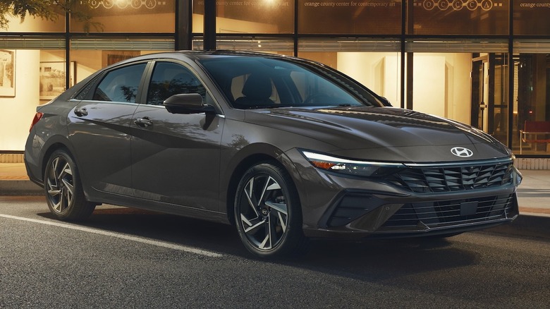 gray 2026 Hyundai Elantra Hybrid parked in front of a store at night