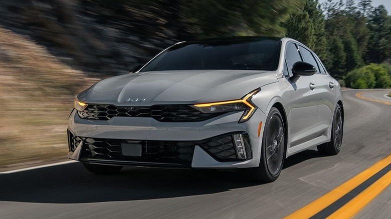 light gray 2026 Kia K5 driving on a curvy road