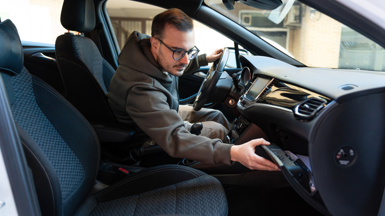 A driver leaning across to open their glove compartment