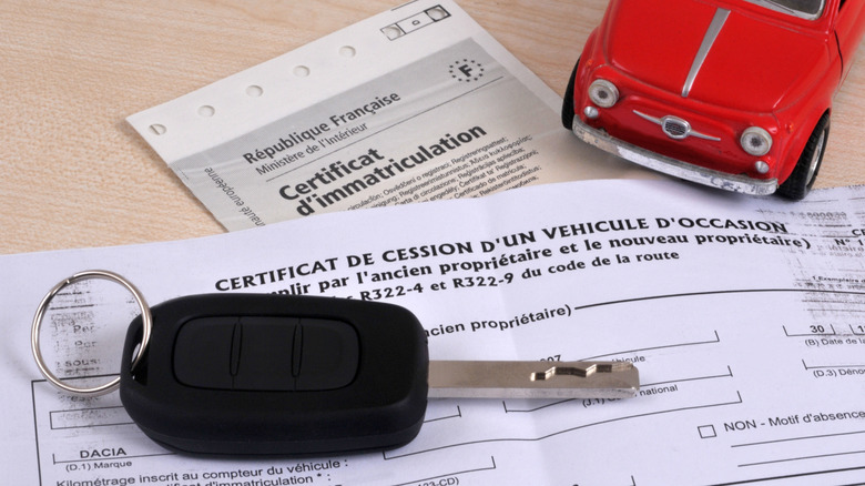 Car key resting on French vehicle registration papers.