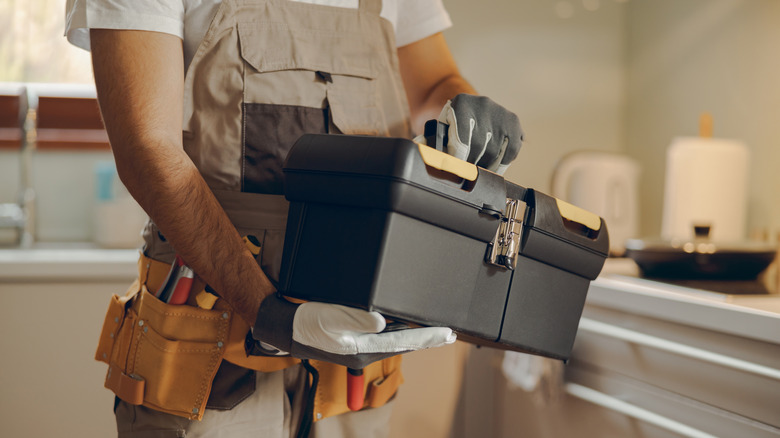 A man holding a tool box in his hands