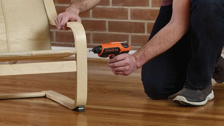 A person using a Black + Decker cordless screwdriver