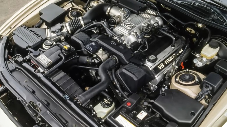 A well-preserved Lexus 1UZ-FE engine labeled "V8 Four Cam 32," neatly arranged in a classic luxury car's engine bay.