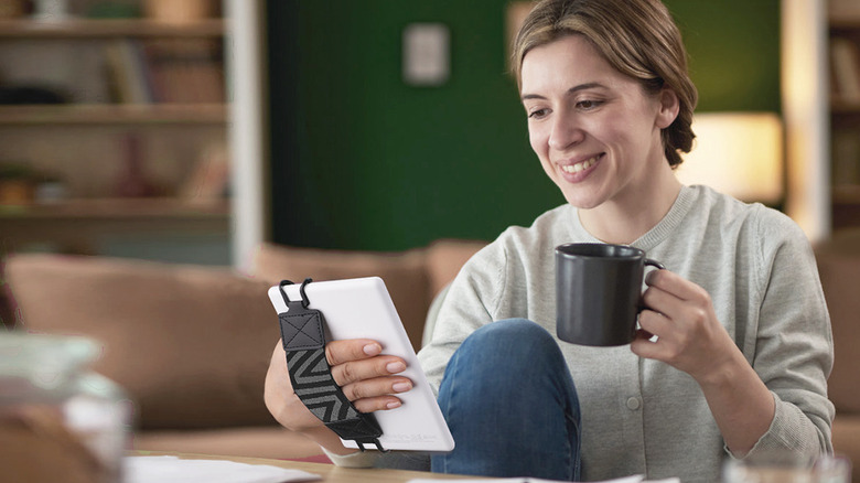 woman holding coffee cup with Kindle