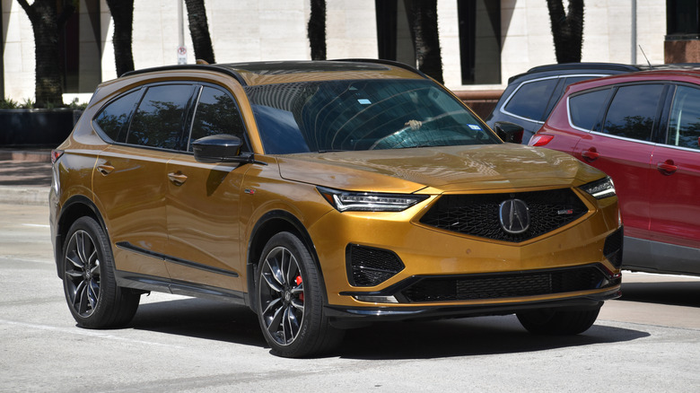 Yellow Acura MDX driving on street